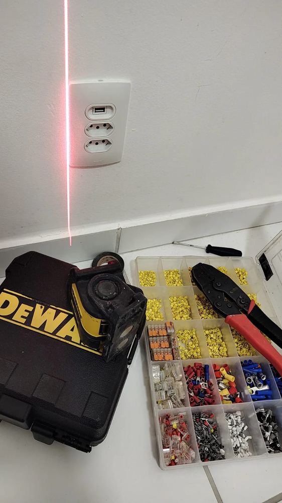 Nível a laser e organizador de terminais elétricos usados na instalação de tomadas